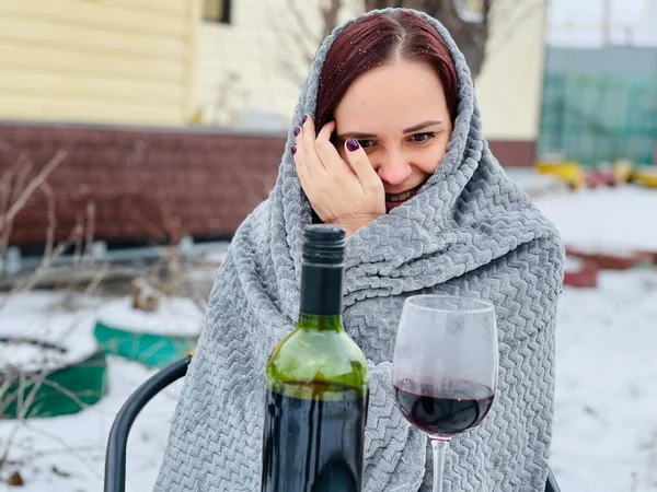 Młoda Kobieta Siedzi Podwórku Pije Czerwone Wino Śnieżnej Pogodzie Kobieta — Zdjęcie stockowe