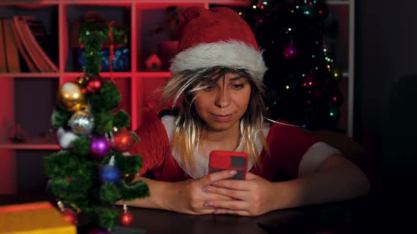 Noel Baba Kostümü Giymiş Genç Bir Kadın Ofisinde Akıllı Telefon — Stok video