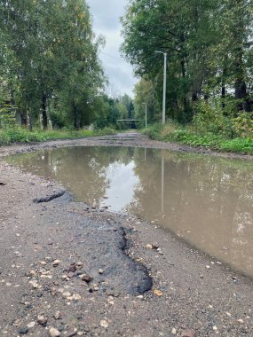 Köy yolunda büyük su birikintileri var. Kırsaldaki yolda su engelleri