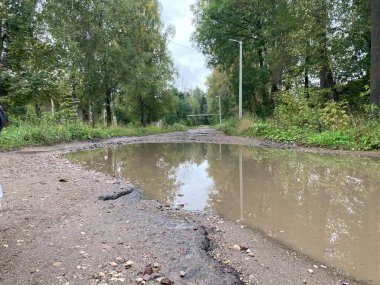 Köy yolunda büyük su birikintileri var. Kırsaldaki yolda su engelleri