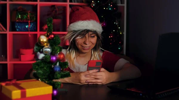 Noel Baba Kostümü Giymiş Genç Bir Kadın Ofisinde Akıllı Telefon — Stok fotoğraf