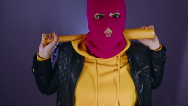 穿着粉色巴拉克拉瓦 戴着棒球棒的年轻女人 带着球棒戴着面具的流氓 — 图库视频影像