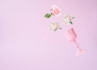 Pembe pastel arka planda pembe camlar ve güllerle yapılmış yaratıcı bahar konsepti.