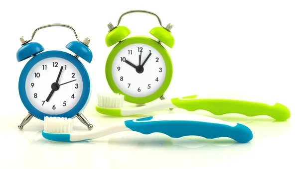 Blue and green clocks and toothbrushes — Stock Photo, Image