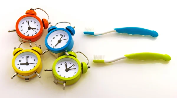 Toothbrushes and colorful clocks — Stock Photo, Image