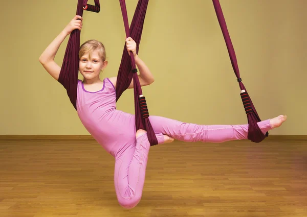 Petite fille faisant des exercices de yoga aérien, intérieur — Photo