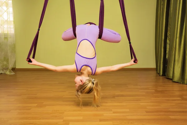 Petite fille faisant des exercices de yoga aérien, intérieur — Photo