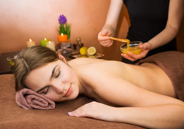 Piękna kobieta w salonie spa o procedurze miód terapii spa — Zdjęcie stockowe