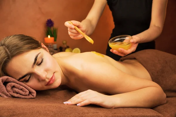Mulher bonita no salão de spa com procedimento de mel terapia spa — Fotografia de Stock