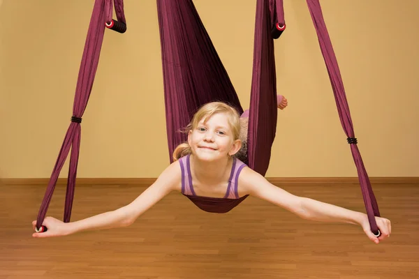 Lilla flickan att göra aerial yogaövningar, inomhus — Stockfoto