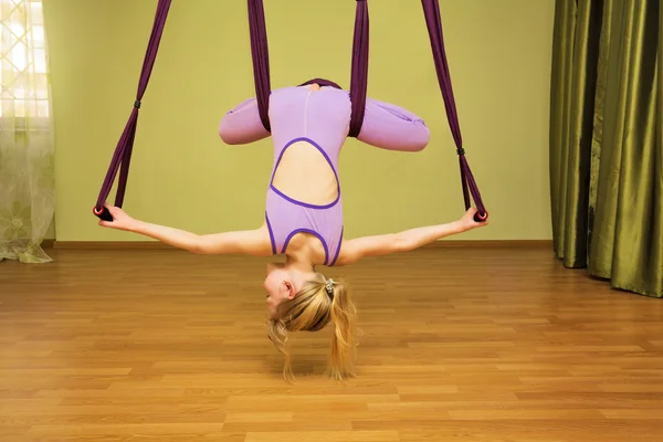 Ragazzina che fa esercizi di yoga aerea, indoor — Foto Stock