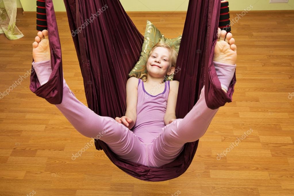 Little girl making aerial yoga exercises, indoor Stock Photo by