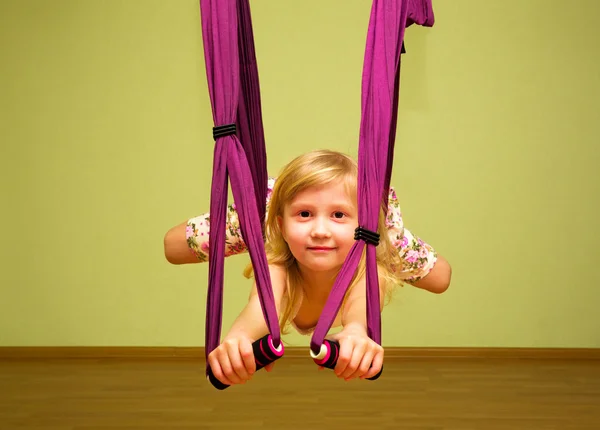 Lilla flickan att göra aerial yogaövningar, inomhus — Stockfoto