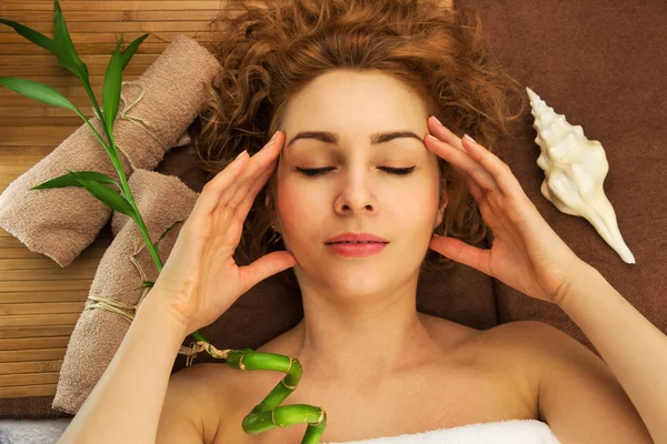 Concepto de spa con hermosa mujer joven, concha, bambú y toallas, ojos cerrados — Foto de Stock