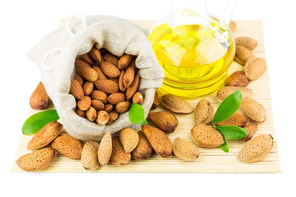 Almonds in the sack and almond oil — Stock Photo, Image