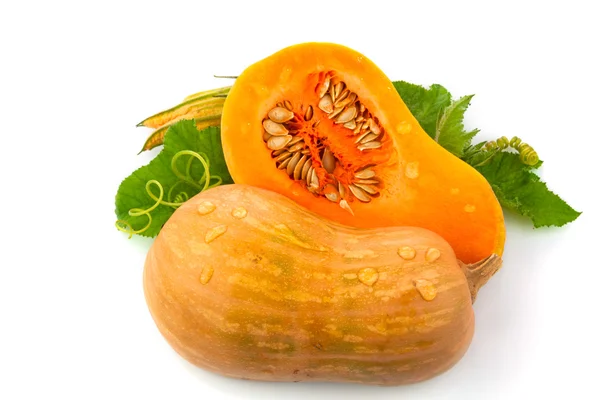 Cut pumpkin with pumpkin seeds and green leaves — Stock Photo, Image