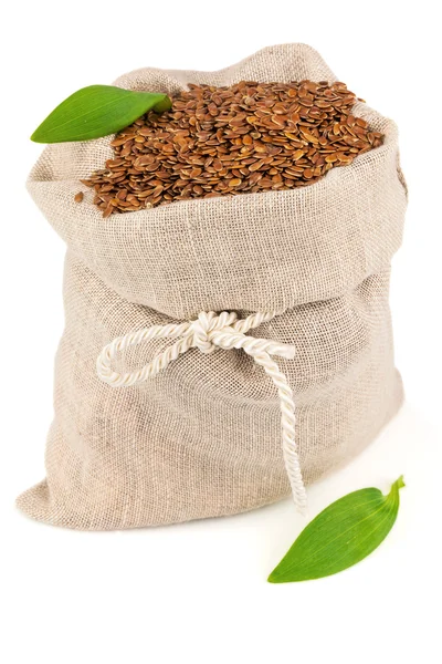 Sack of flax seeds with leaves — Stock Photo, Image