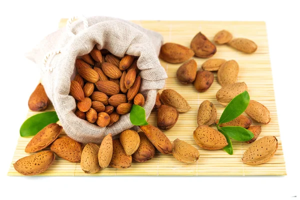 Almonds in sack on mat — Stock Photo, Image