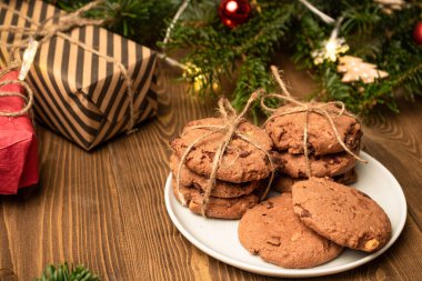 Kurabiyeler, hediye kutuları ve ahşap bir masada ladin dalı. Yan görünüm.