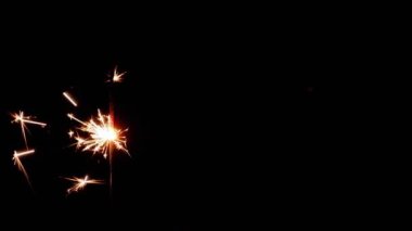 Havai fişek ve siyah arkaplandan süzülen sarı bir kabuğun yavaş video klibi.