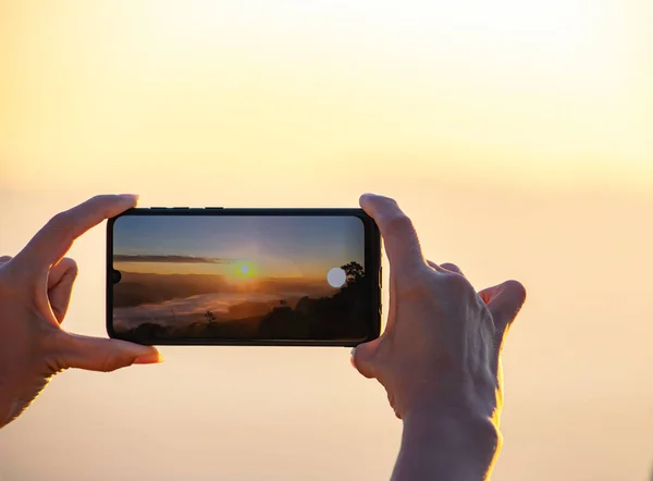 Mano Sosteniendo Teléfono Disparando Sol Mañana Niebla — Foto de Stock