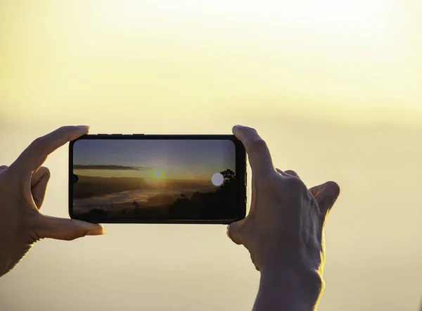 携帯電話を手に 朝の太陽と霧を撮影 ストック画像