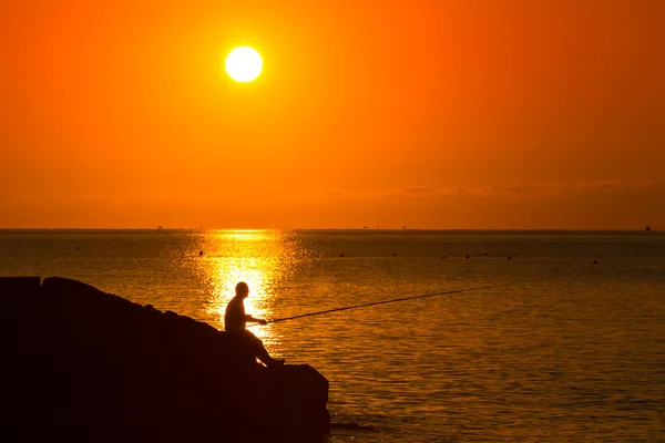 Silhouet van visser op de zonsondergang — Stockfoto
