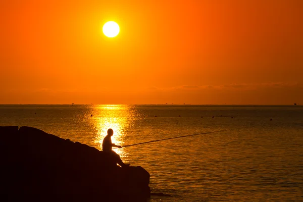 Silueta del pescador al atardecer — Foto de Stock