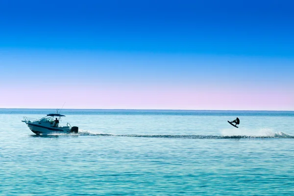 Silueta motorového člunu a skákání wakeboarder — Stock fotografie