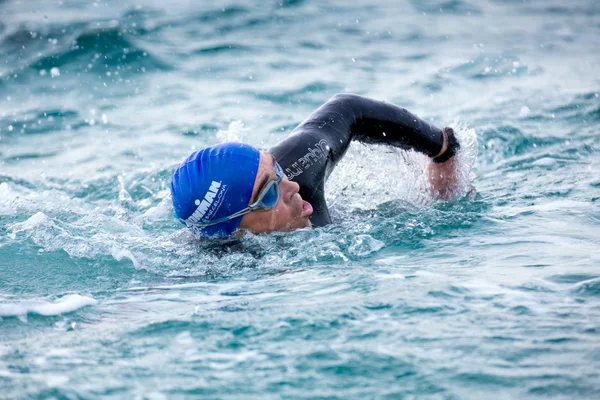 Calella, İspanya, 18 Mayıs. Triatlet Ironman triatlon rekabet Calella Beach, 18 Mayıs 2014 Calella, İspanya başlangıç üzerinde yüzüyor