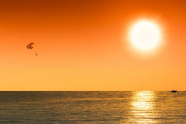 Seppia silhouette dell'uomo parasailing al tramonto — Foto Stock