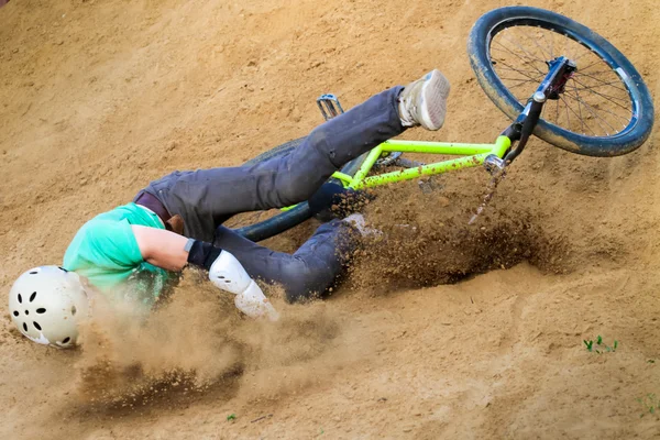 Biker stürzt von seinem Fahrrad in den Sand — Stockfoto