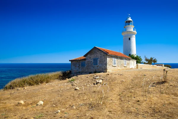 Kayalık kum tepe üzerinde eski beyaz deniz feneri
