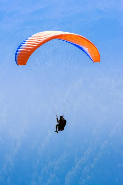 Parapente vermelho no céu azul sobre os picos dos Alpes — Fotografia de Stock