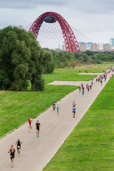 Triatlon rekabet Askılı kırmızı Jivopisny Bridge ile Moskova'da sırasında triathletes çalıştırmak
