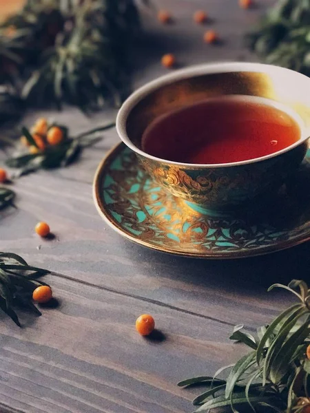 Чай с морским клювом в красивой зеленой чашке на деревянном фоне — стоковое фото