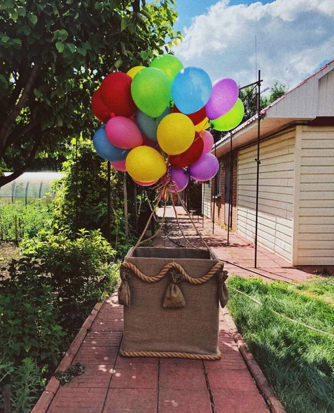 Hot air balloon basket with banch of balloons
