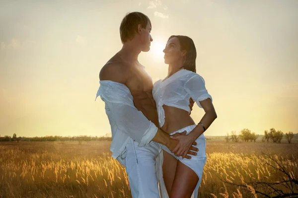 Pareja romántica en el campo al atardecer — Foto de Stock