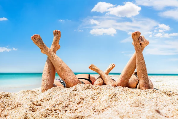 Várias meninas deitadas na praia de areia — Fotografia de Stock