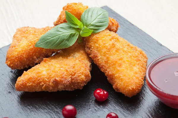 Gebratene Käsesticks mit Preiselbeeren, Sauce auf schwarzem Stein lizenzfreie Stockfotos