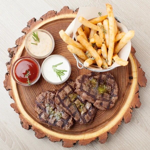 Porção de churrasco filé mignon carne com molhos e batatas fritas — Fotografia de Stock