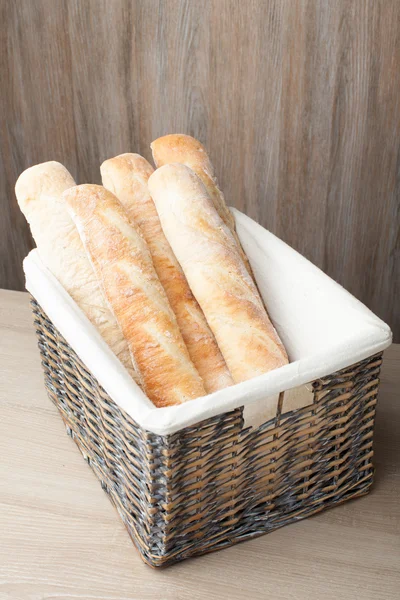 Loafs de baguete pão francês tradicional estocado em bask tecido — Fotografia de Stock