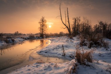 Piaseczno, Masovia, Polonya yakınlarındaki Jeziorka nehrinin üzerinde gün batımı