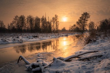 Piaseczno, Masovia, Polonya yakınlarındaki Jeziorka nehrinin üzerinde gün batımı