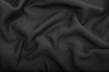 Kumaşta pliseler, koyu gri renkli örgü kumaşlar, kıvrımlar.