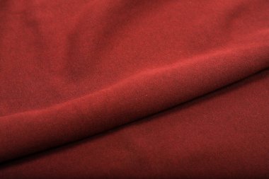 Kumaşta pliseler, kırmızı renkli örgü kumaşlar, kıvrımlar.