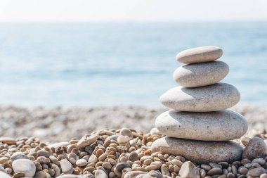 Zen rahatla. Güneşli bir havada kumsalda taş piramidi. Meditasyon, yoga ve masaj için arka plan