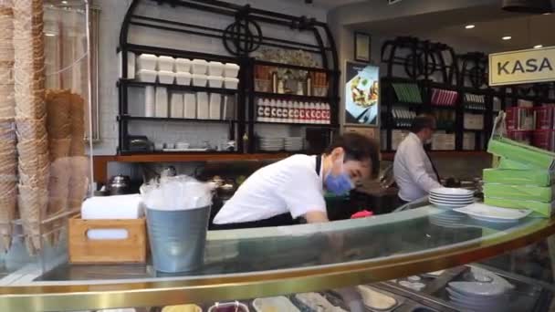 Vendedor de sorvete em uma máscara protetora em uma pastelaria. Cafés e restaurantes em Istambul. Ruas turísticas e vida de rua em Istambul — Vídeo de Stock