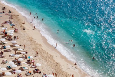 Turkuaz plajı manzarası. Güzel Kaputas Sahili (Türkiye) insanların güneşin altında ve denizde dinlendiği