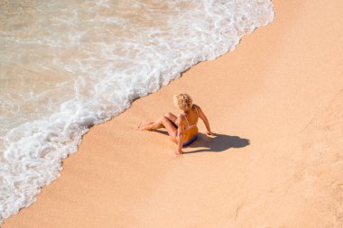 Güneşin altındaki boş bir deniz turkuaz plajında yalnız bir adam. Denizde dinlenme ve dinlenme.